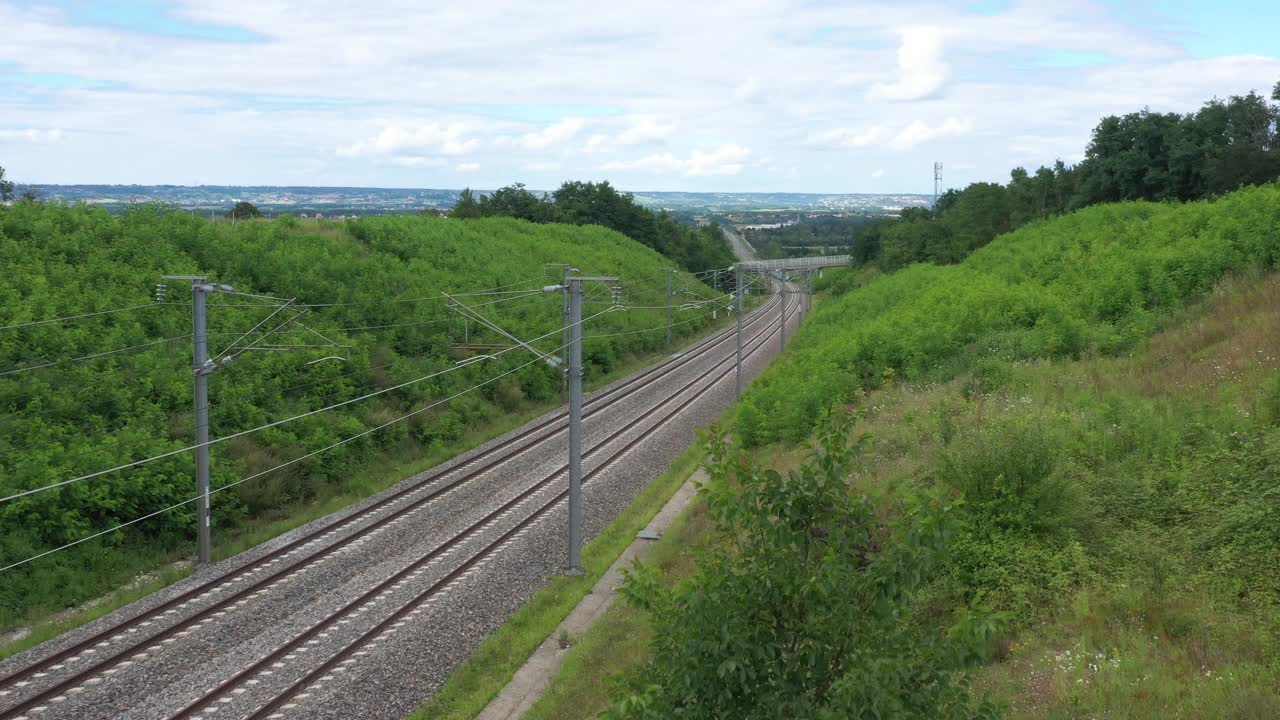 法国，法国TGV OUIGO高速列车通过田野和桥下，无人机鸟瞰图视频素材