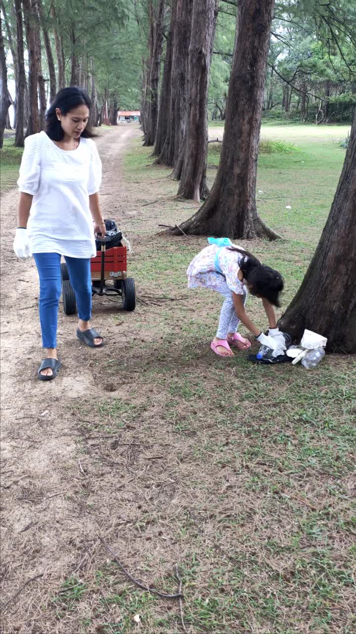 一个亚洲家庭用轮椅把垃圾放在海边公园里，以适当地限制垃圾。视频素材