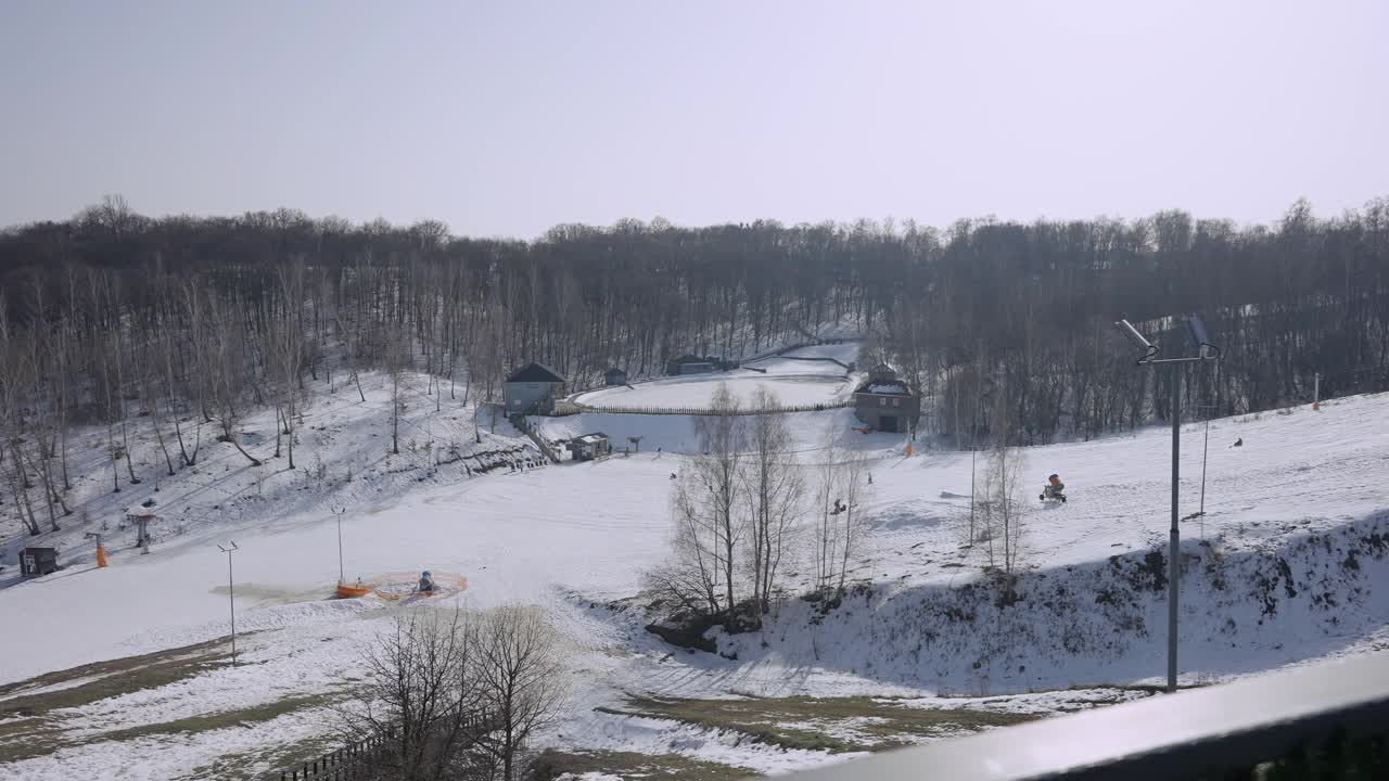 冬季度假胜地在户外阳光的广角镜头。在阳光下滑雪和滑雪的雪坡上，不知名的游客。休闲旅游理念。视频下载