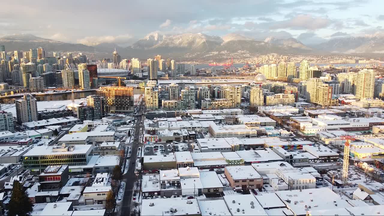 温哥华商业建筑的鸟瞰图，山上和市中心覆盖着积雪和夕阳的光视频素材