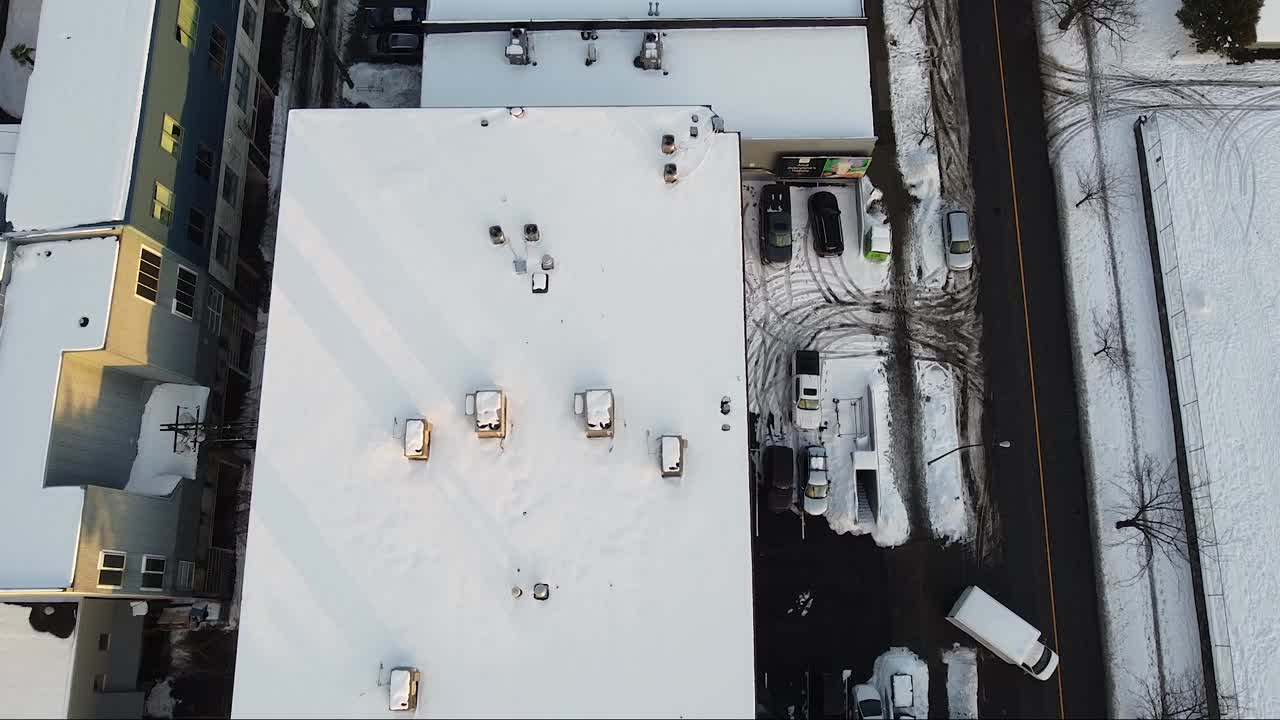 飞过积雪的屋顶和工地上的起重机视频素材