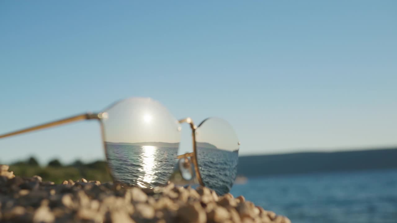 在海滩上拥抱的情侣戴着太阳镜的倒影视频素材