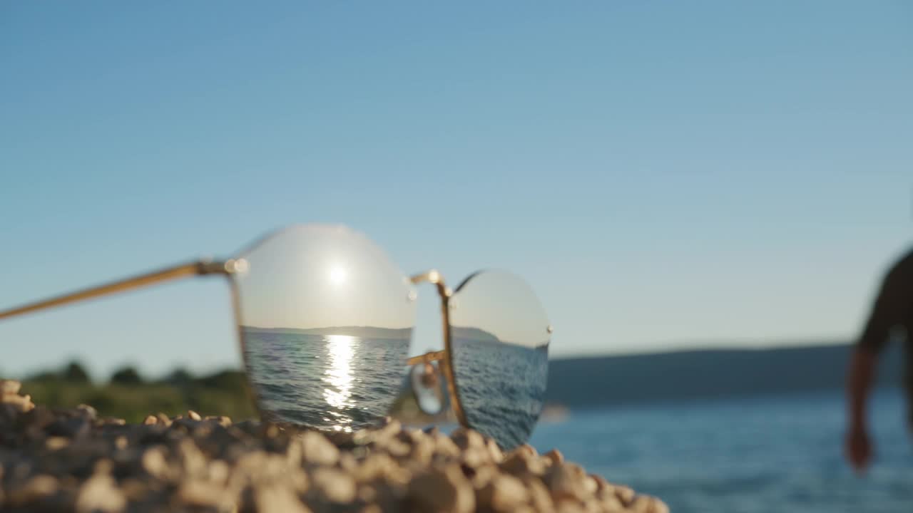在海滩上拥抱和跳舞的情侣的太阳镜反射视频素材
