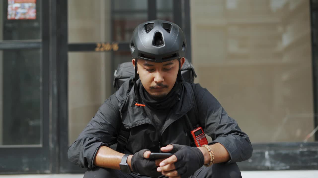 亚洲快递员用智能手机查看送货方向视频素材