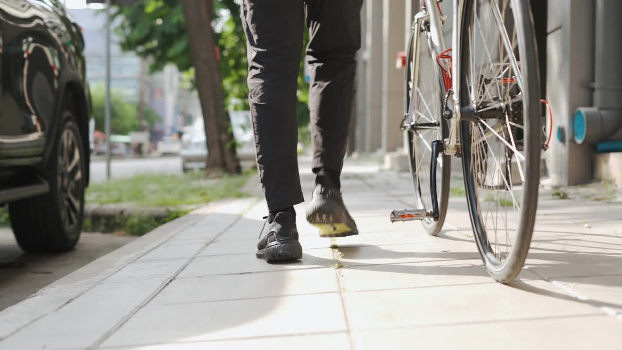 亚洲快递员走路，拖着自行车视频素材