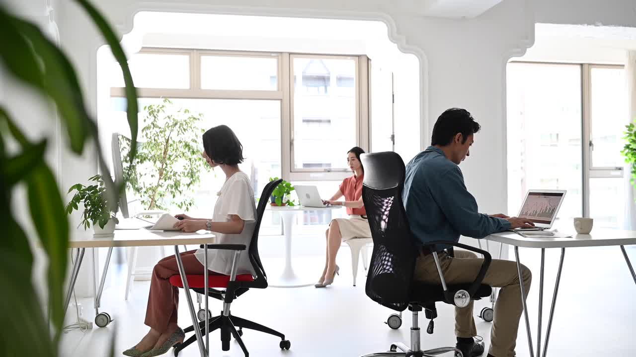 亚洲上班族在明亮宽敞的办公室里工作。视频下载