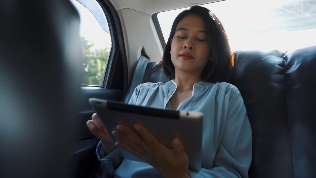 亚洲女人在车里用平板电脑视频素材