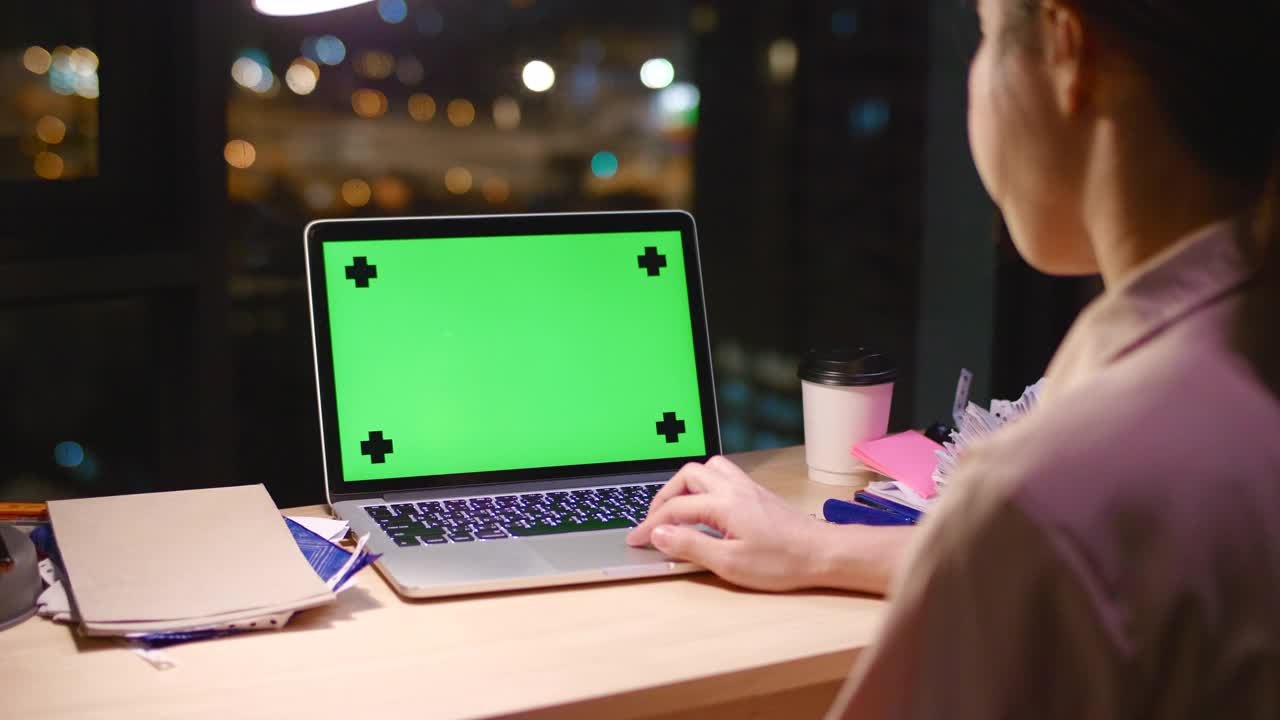 女人在晚上使用绿色屏幕的笔记本电脑视频下载