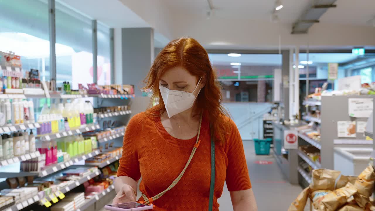 一名妇女在流行病期间在百货商店购买食品杂货视频素材