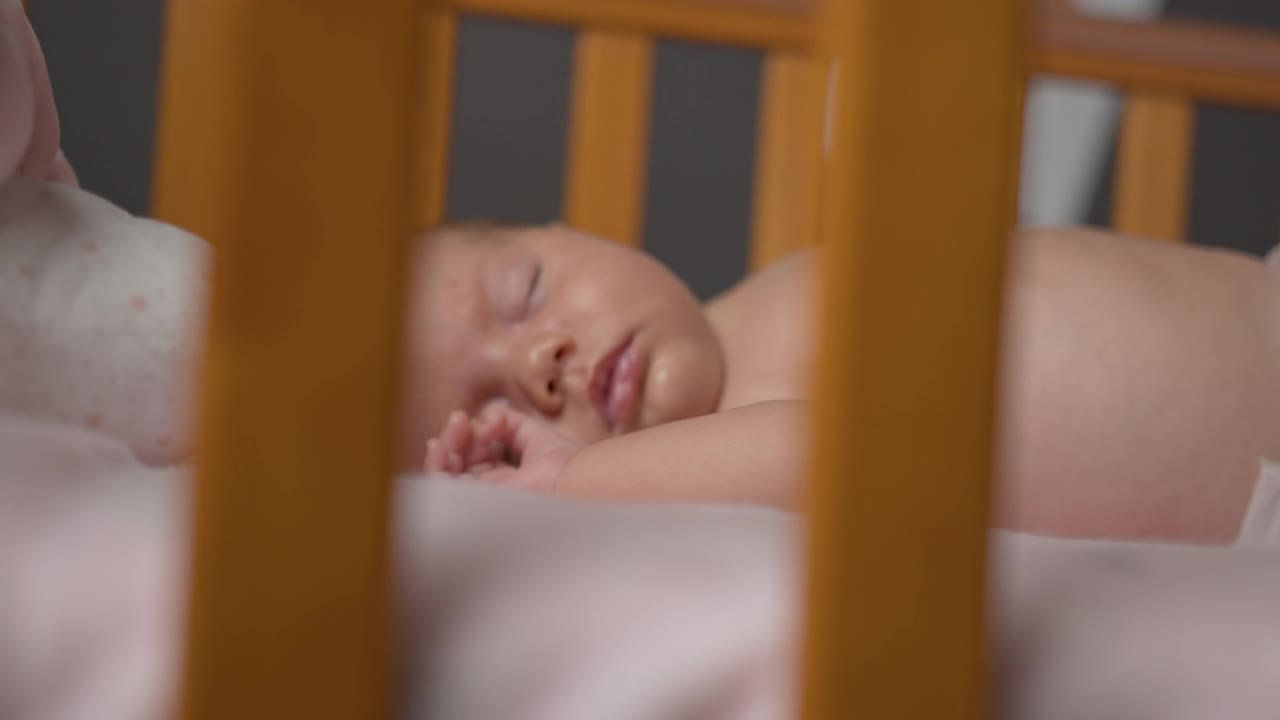 小男孩仰面睡在婴儿床上视频下载