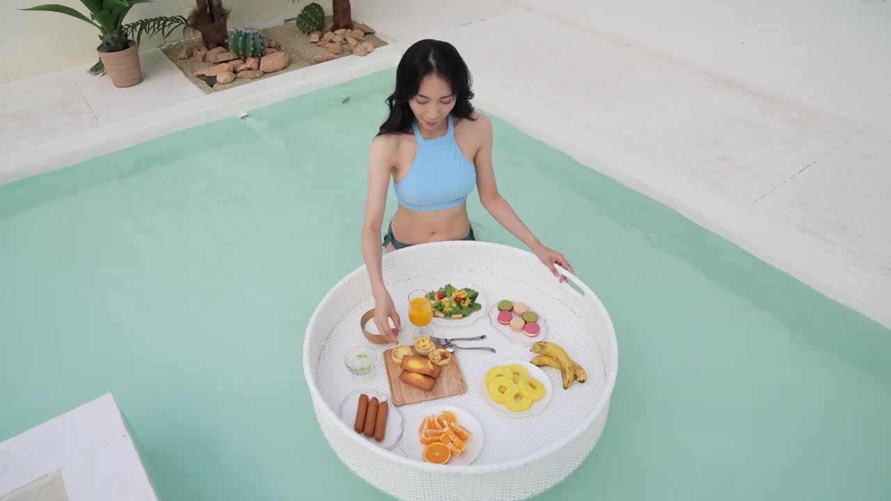 年轻的女人在比基尼享受与浮动的餐桌视频下载