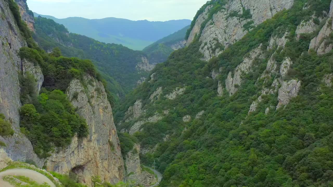 山路在山崖之间，岩石上有美丽的绿色植被。视频素材