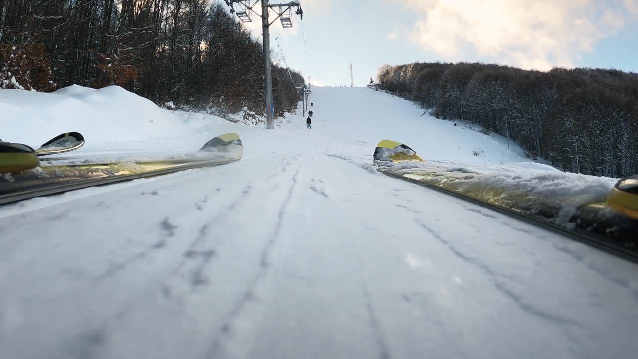 低视野的一对夫妇的滑雪板骑在t杠上山视频素材