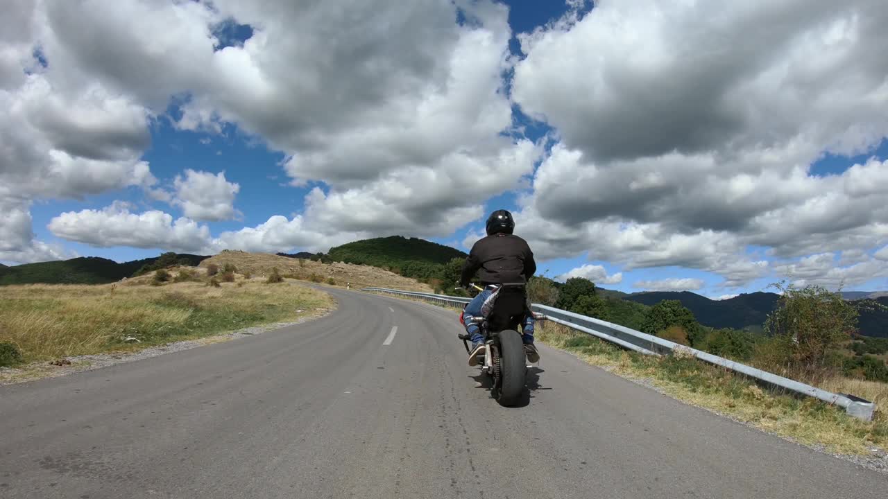 高速摩托车特技公路骑行。在乡间山路上驾驶危险的轮车视频素材