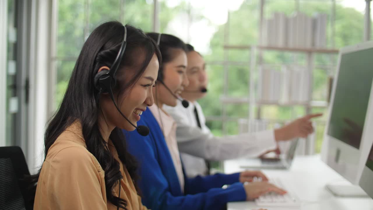 亚洲女性呼叫中心代理与客户在她的工作站交谈视频素材