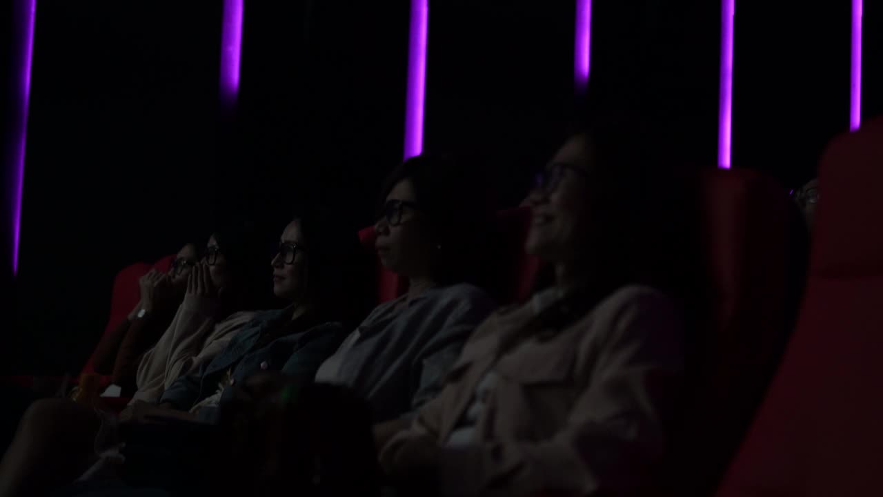 一群亚洲观众带着3D眼镜在电影院观看3D电影视频下载