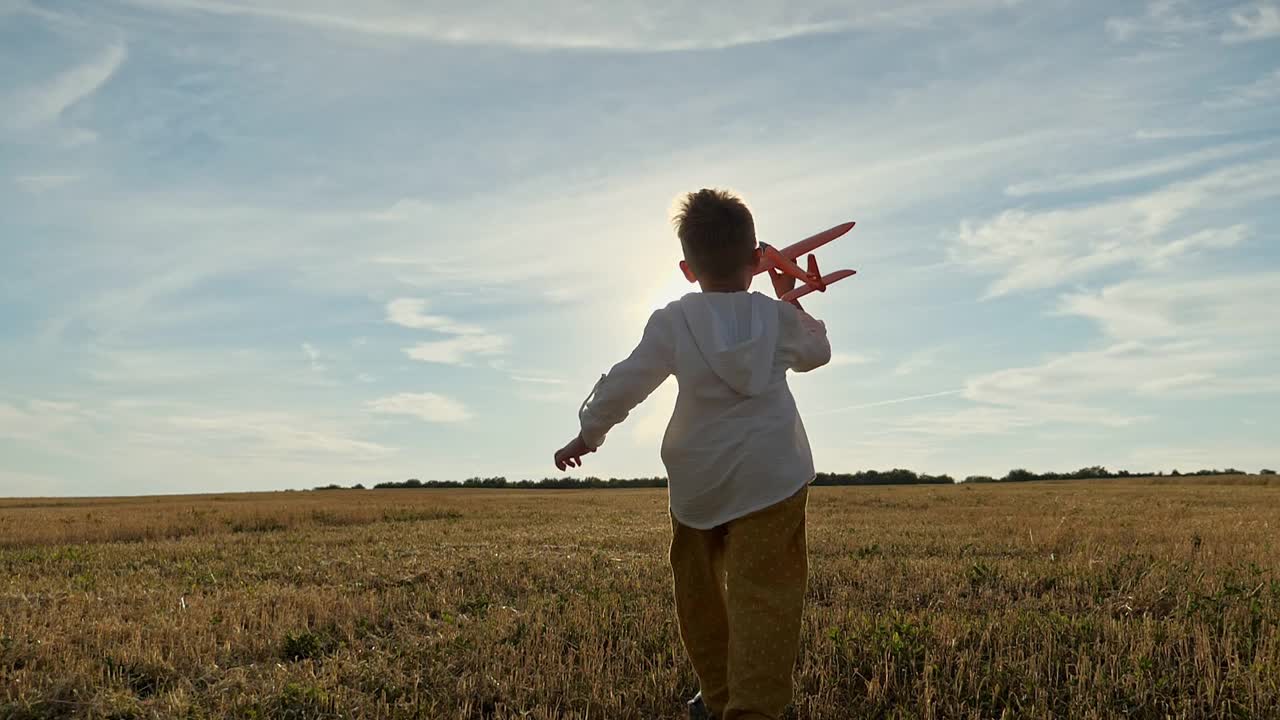 男孩手里拿着玩具飞机在田里跑，开着飞机视频下载