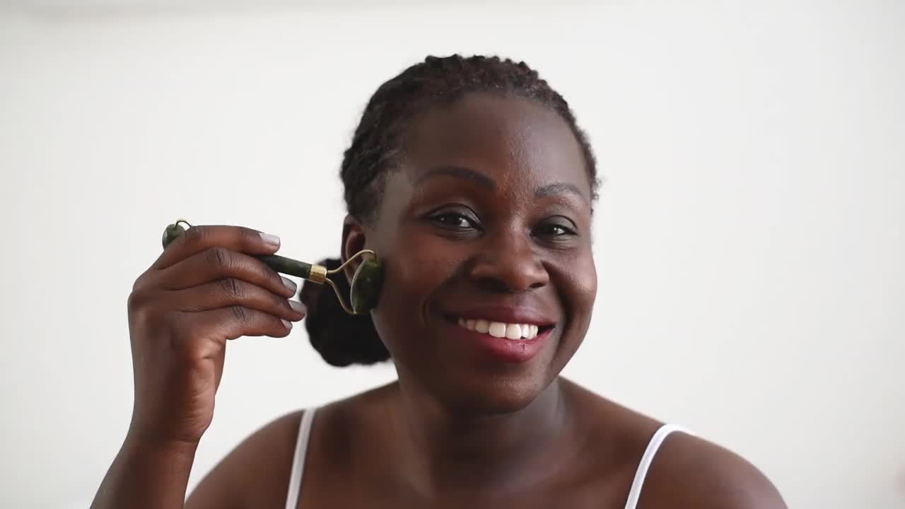 皮肤护理使用玉面部滚轮黑色女人视频素材