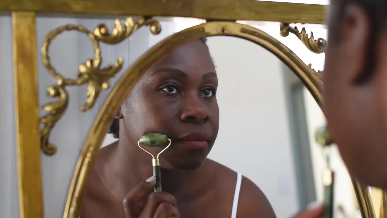 皮肤护理使用玉面部滚轮黑色女人视频素材