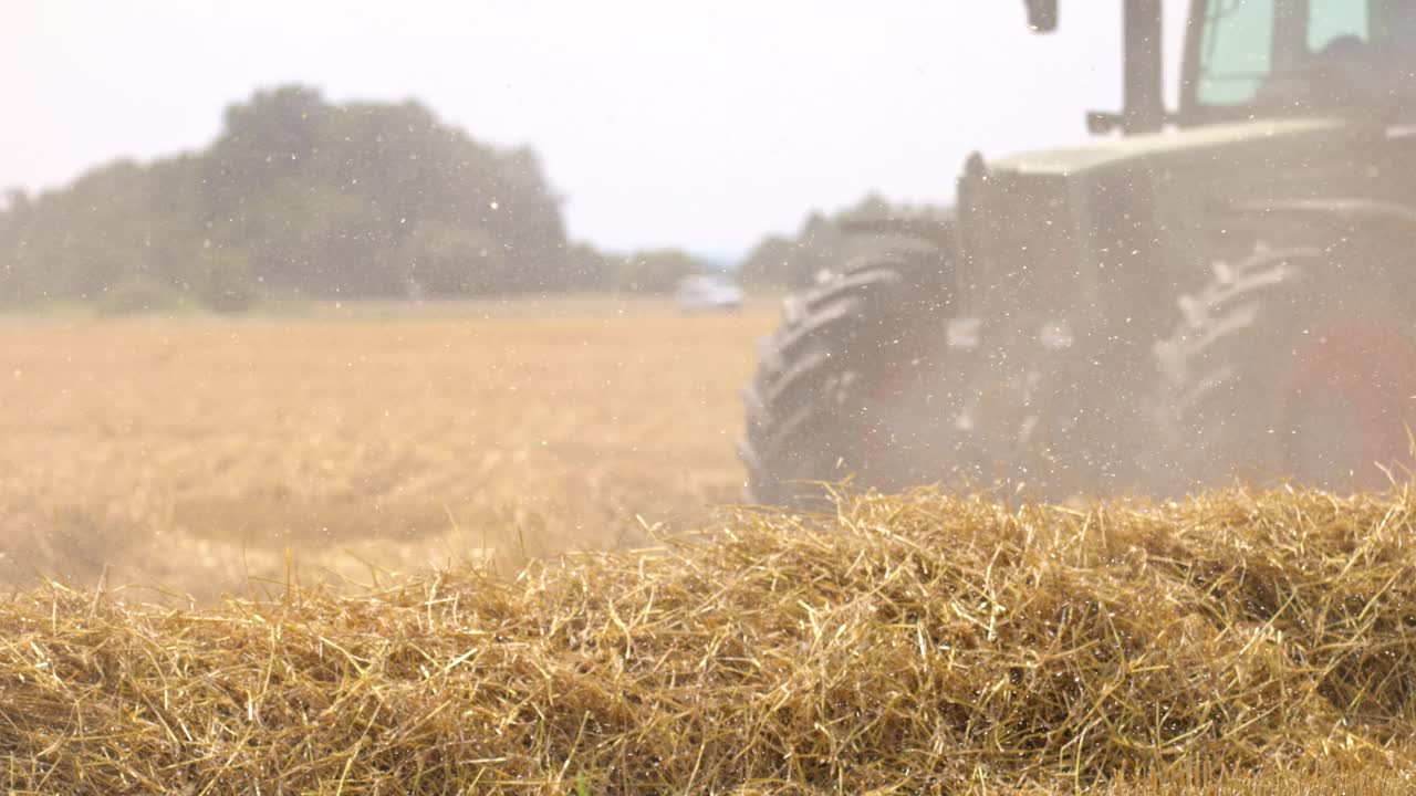SLO MO联合收割机收割小麦，同时拖拉机驱动拖车视频下载