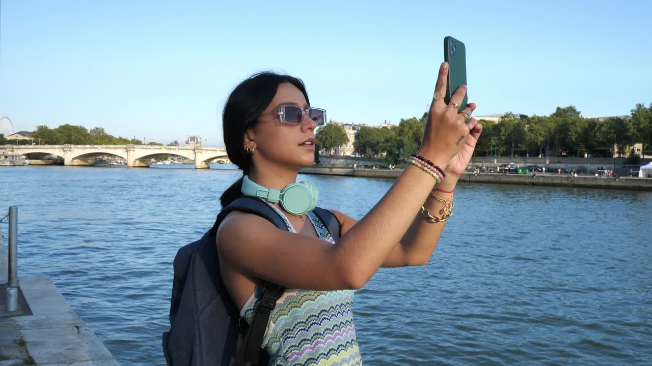 年轻的游客背着背包，在夏天的巴黎享受城市假期，拍摄埃菲尔铁塔视频素材