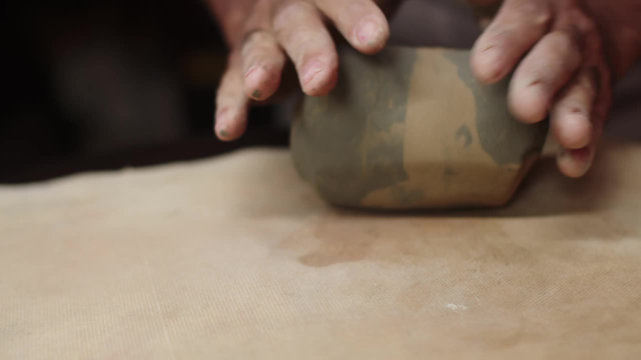 陶工用手在桌子上捏粘土，并准备它用于生产产品，宏观。用粘土制作陶器的过程。艺术与创意理念视频下载