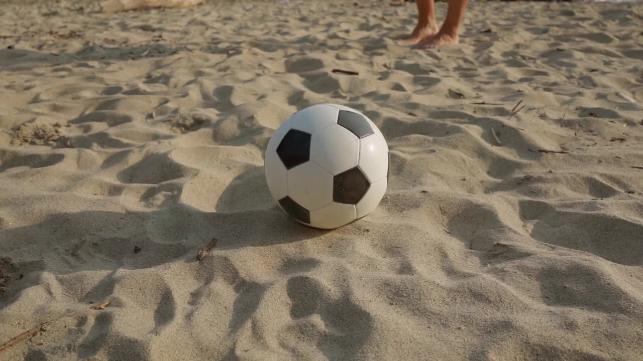沙滩足球。一个男人打了一个经典的黑白皮球。以外的其他视频素材