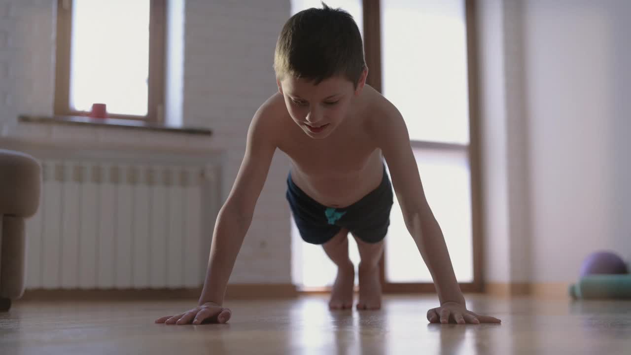 积极健康的年轻男孩在室内做俯卧撑，肌肉运动，休闲活动的生活方式视频下载