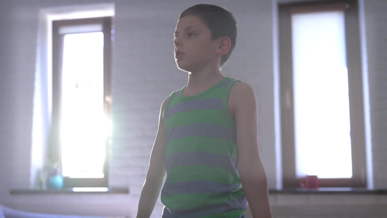 健康活跃的高加索小强壮的男孩在条纹背心举重哑铃在室内家庭运动训练娱乐健身锻炼视频下载