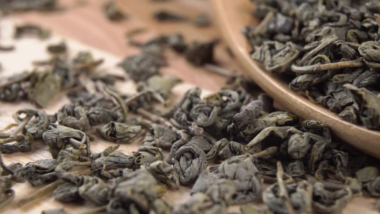 有机生态产品绿色干燥的茶叶在一个木勺在一个乡村板视频素材