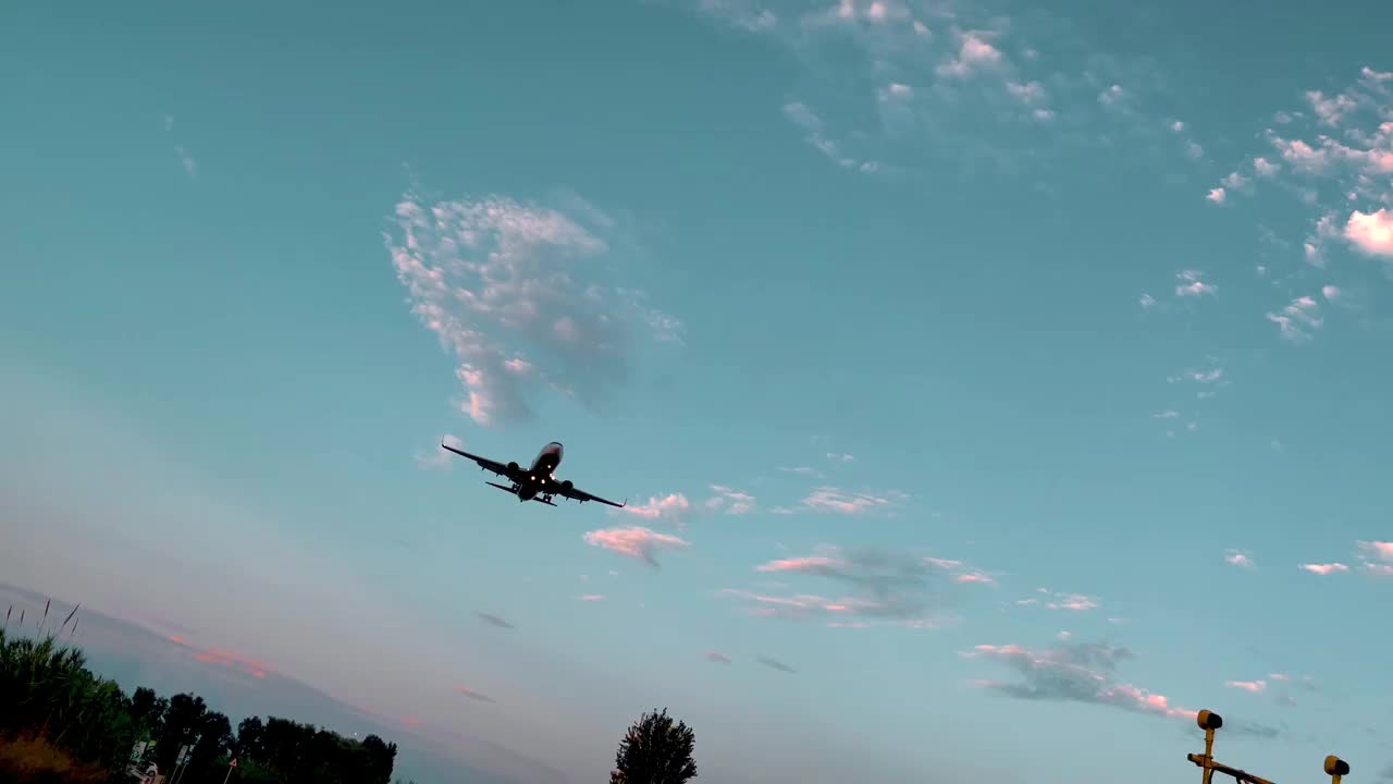 日落时分，飞机降落在巴塞罗那国际机场。在巴塞罗那机场观看飞机如何从下面降落。视频素材