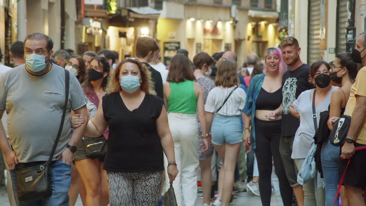 2021年夏天，西班牙拥挤的街道上挤满了年轻人。有些人戴着面具视频下载