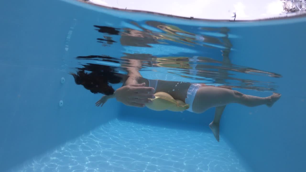 孕妇在游泳池里放松和伸展视频下载
