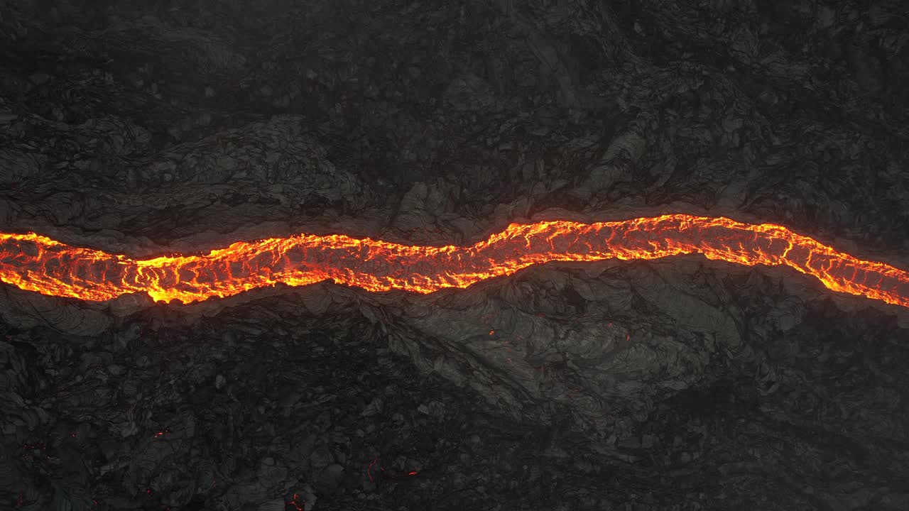 无人机拍摄的视频显示，一条像蛇一样的熔岩河从冰岛雷克雅内半岛的Fagradalsfjall火山缓缓流过视频素材