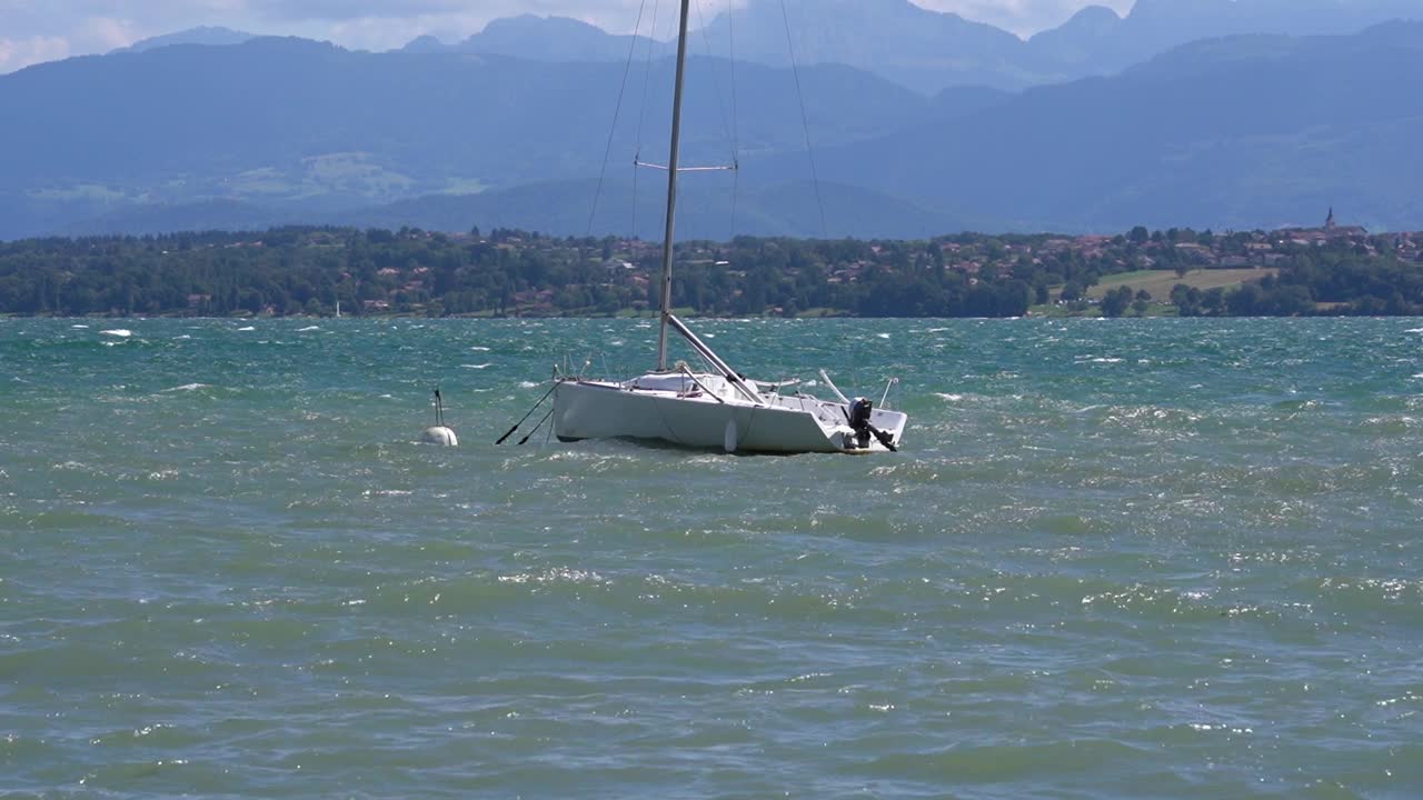 阳光明媚的一天，帆船在日内瓦湖的波浪中摇摆。视频素材