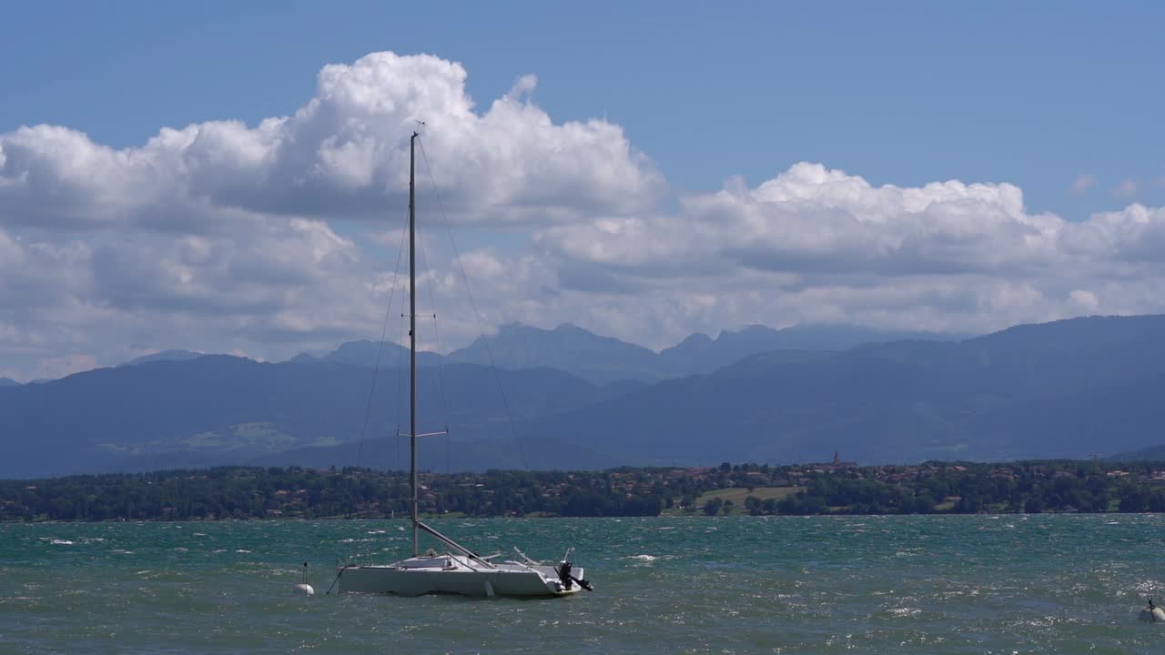 阳光明媚的一天，帆船在日内瓦湖的波浪中摇摆。视频素材
