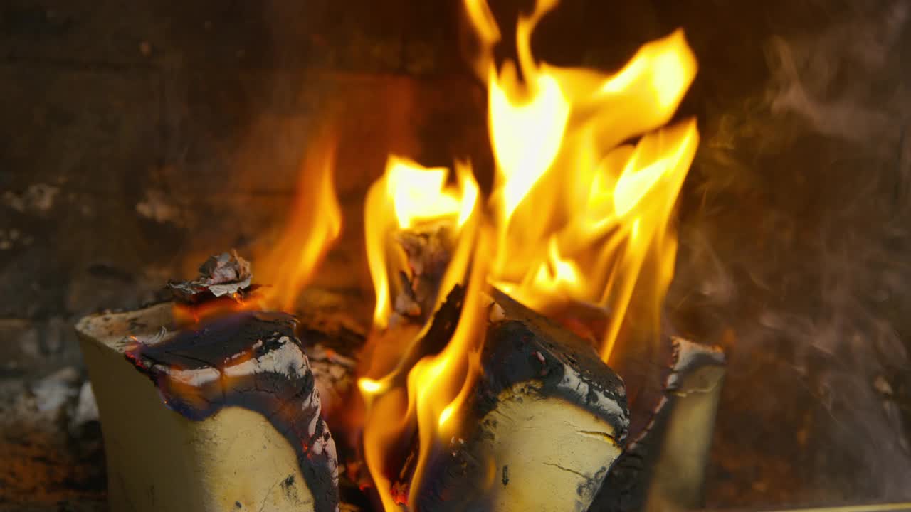 靠近壁炉的火焰。用火砖在石头壁炉里燃烧木柴。视频素材