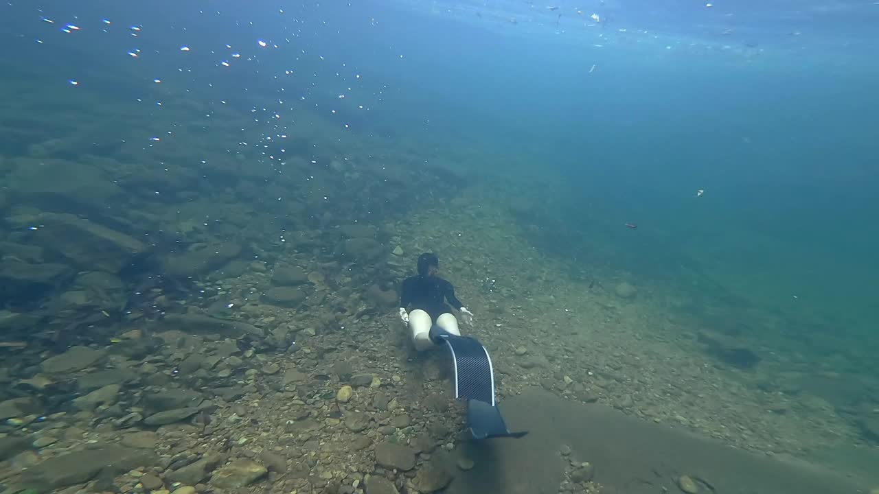 亚洲女子在清澈的水中自由潜水。视频下载