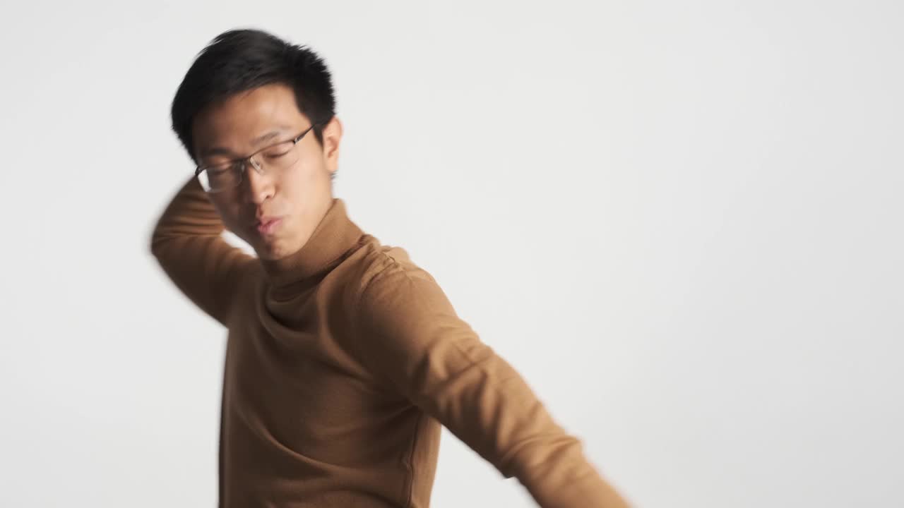 年轻帅气的亚洲男子戴着眼镜，手挽着手欢快起舞视频下载