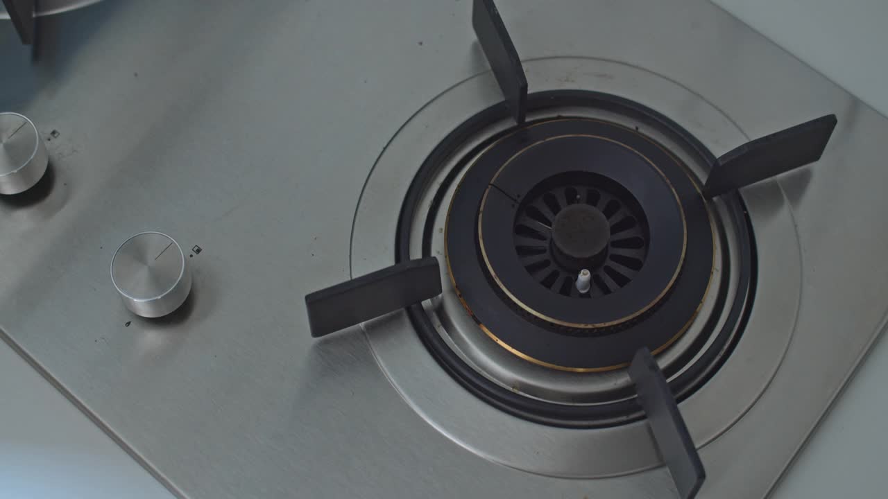 用手转动厨房里炉子的旋钮，打开和关闭煤气视频素材