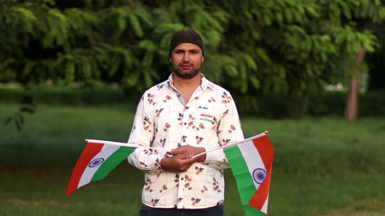 年轻的印度男人双手拿着三色旗视频下载