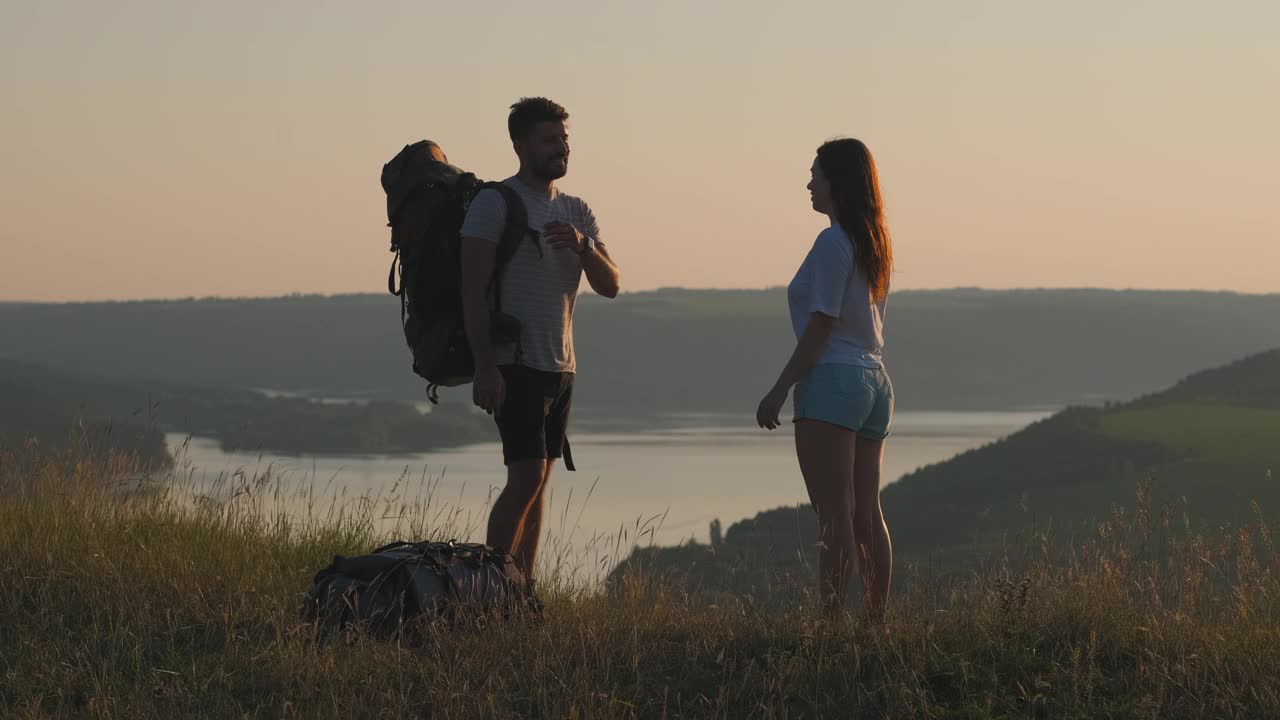 两位游客站在美丽的山顶上。慢动作视频素材