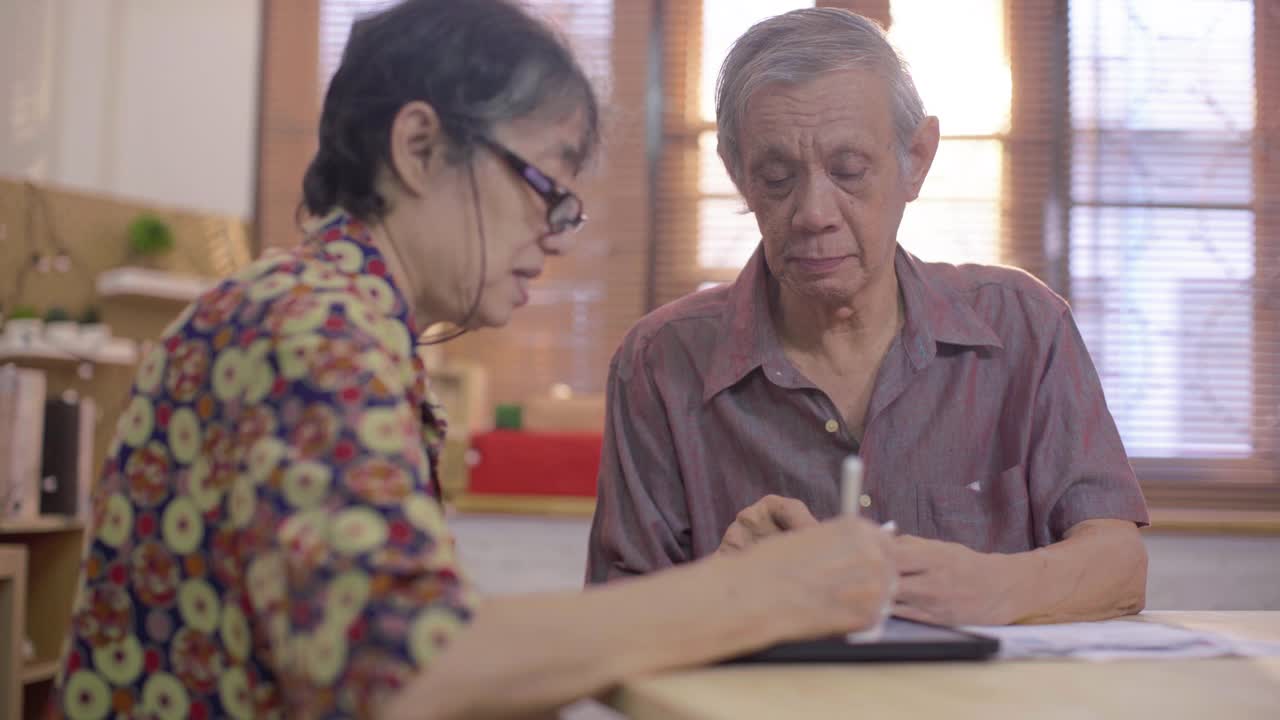 亚洲老男人和女人使用手机扫描和支付家庭财务账单视频素材