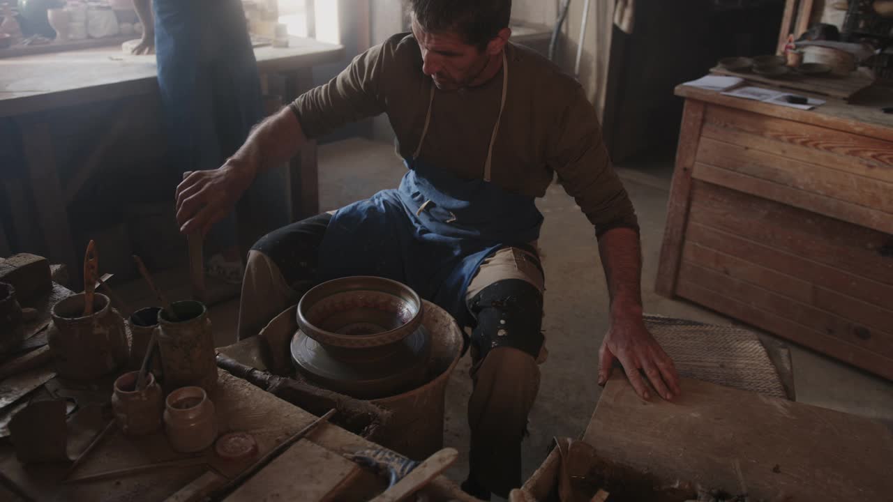 SLO MO Potter在陶艺车间工作时完成了一个小碗视频素材