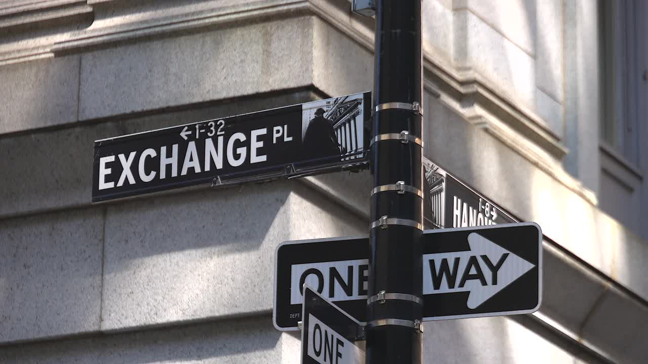 在纽约金融区，街道指示牌矗立在建筑物之间的街道上。视频下载