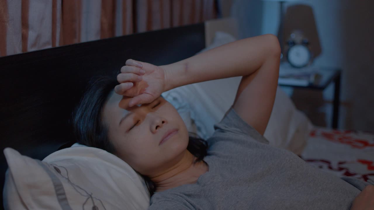抑郁的亚洲女性不能睡在床上。失眠综合症无眠视频下载