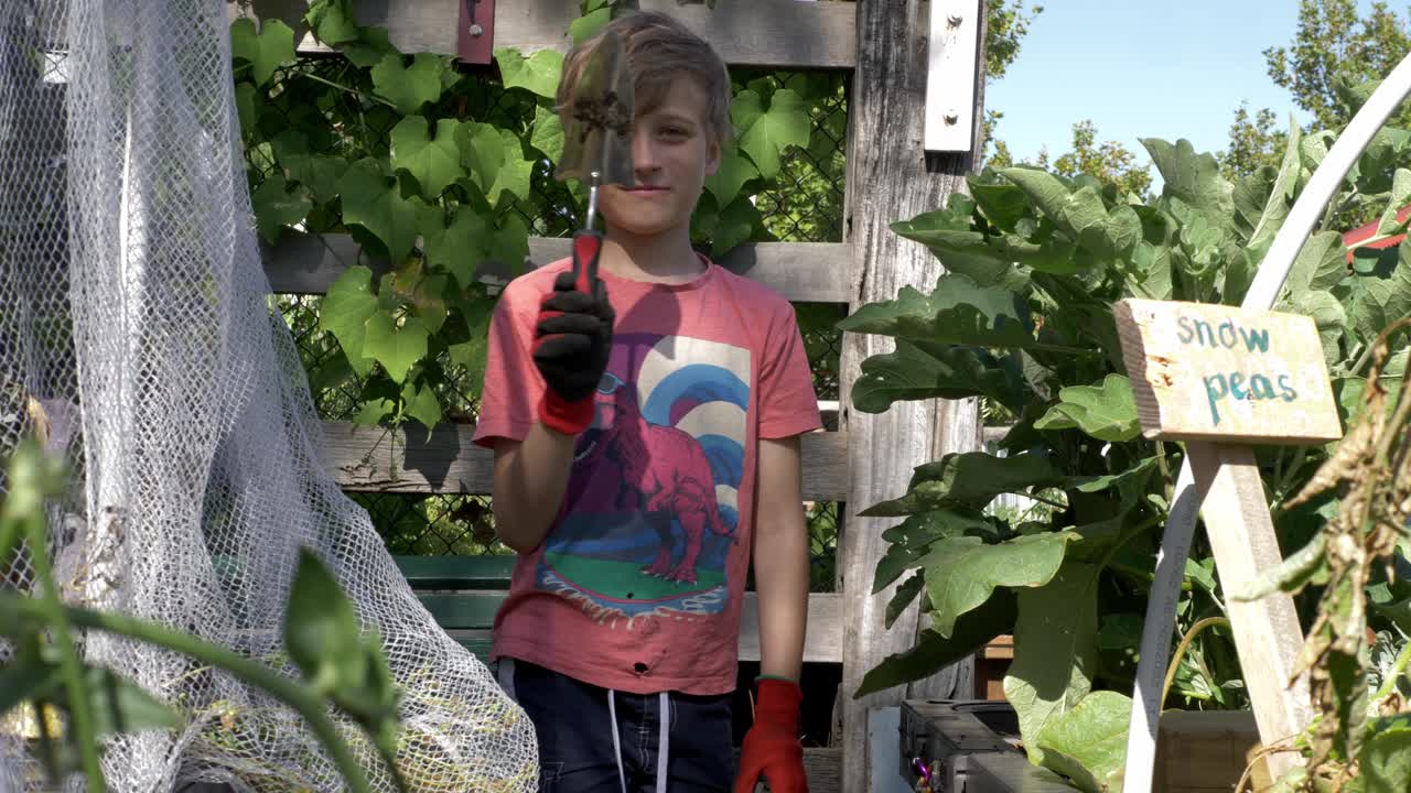 骄傲的男孩拿着园艺工具视频素材