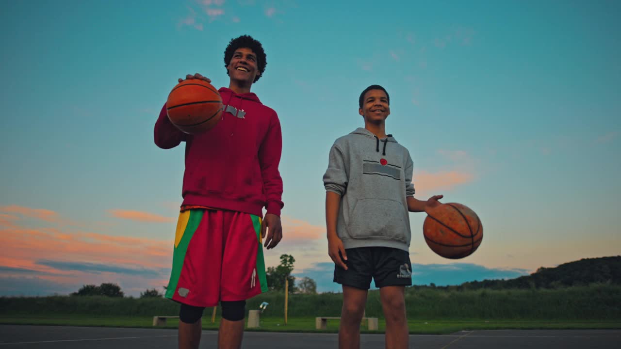 两兄弟在篮球场上打球视频素材