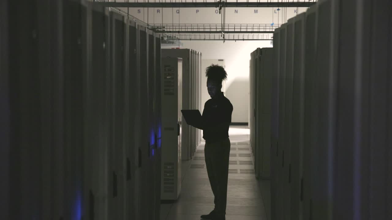 数据中心工作时使用笔记本电脑的男性IT专业人员的广角镜头视频下载