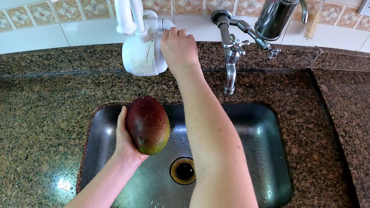 在水槽的水龙头边洗水果视频素材